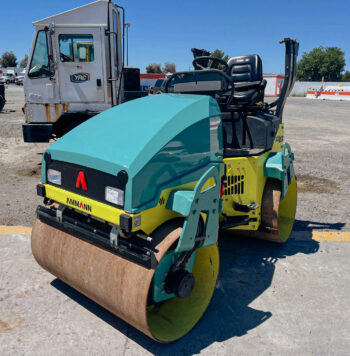 The Ammann ARX26 Roller Compactor seen from a front angle, featuring its 47-inch drums and foldable OROPS. The machine appears clean and well-maintained, indicative of its "like new" condition.